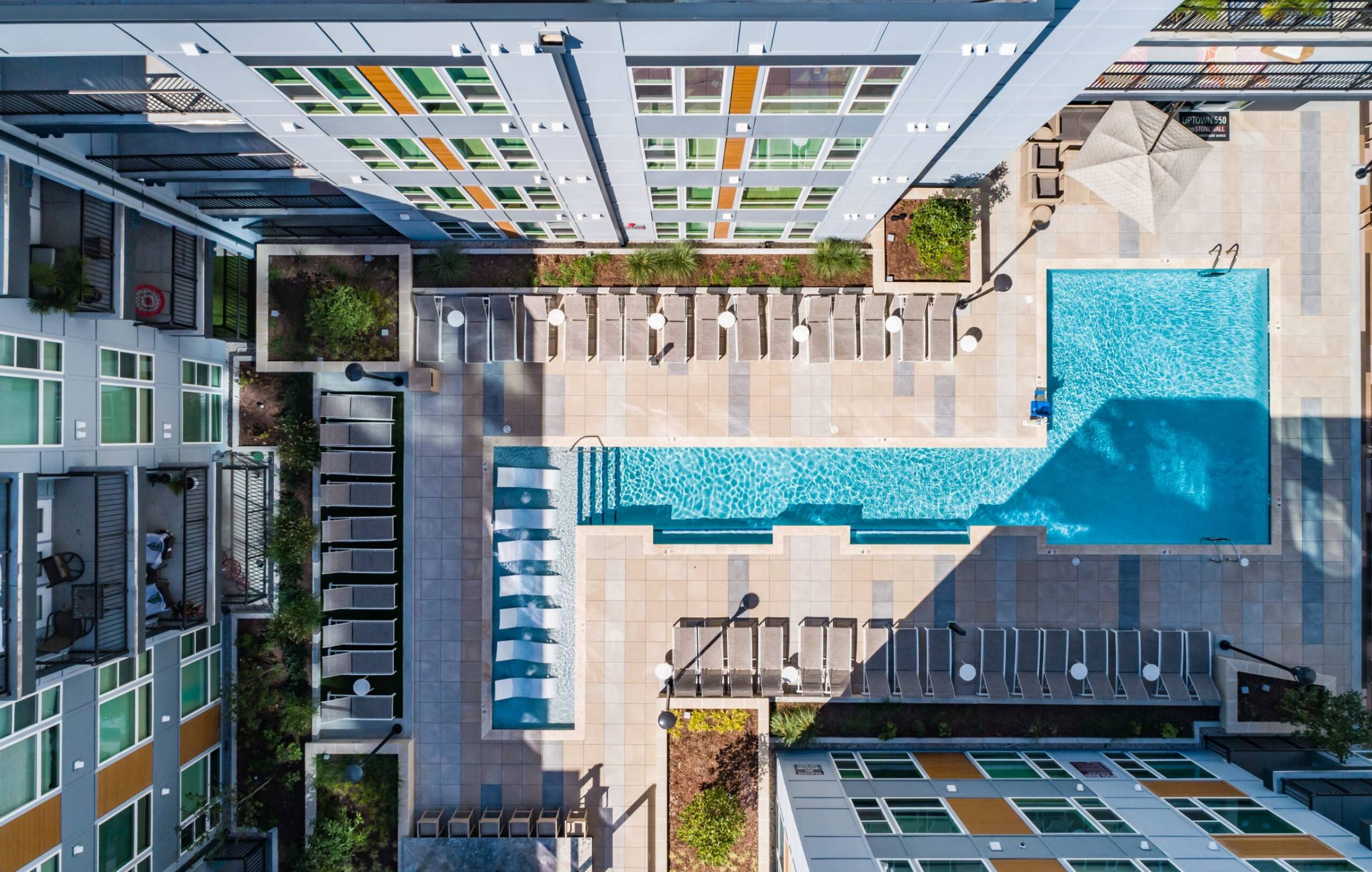 Uptown 550 Luxury apartment building pool with seating area around it.