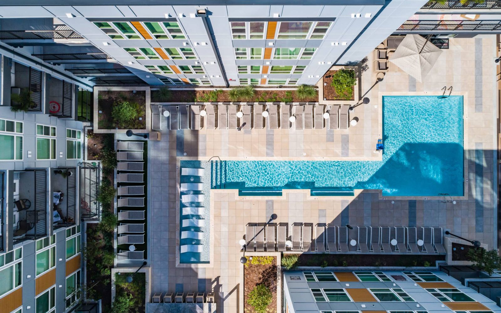 Uptown 550 Luxury apartment building pool with seating area around it.