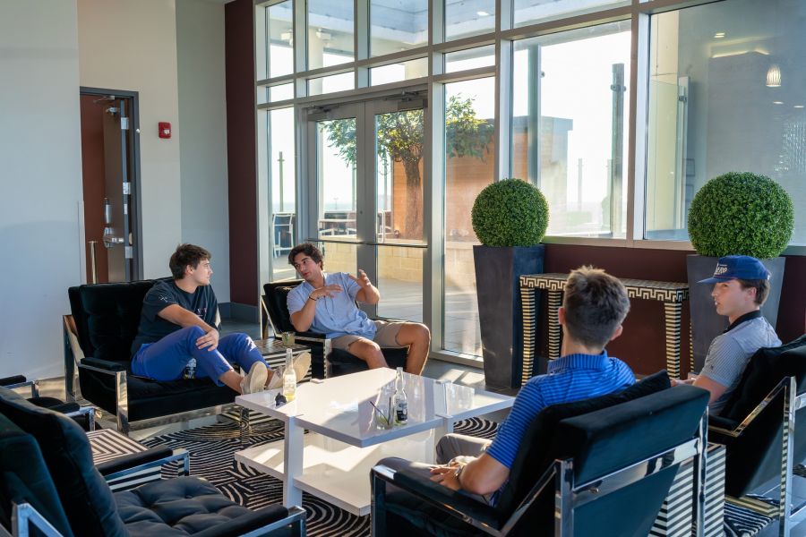 Residents hanging out in the lounge with beers at Uptown 550 on Brooklyn apartments