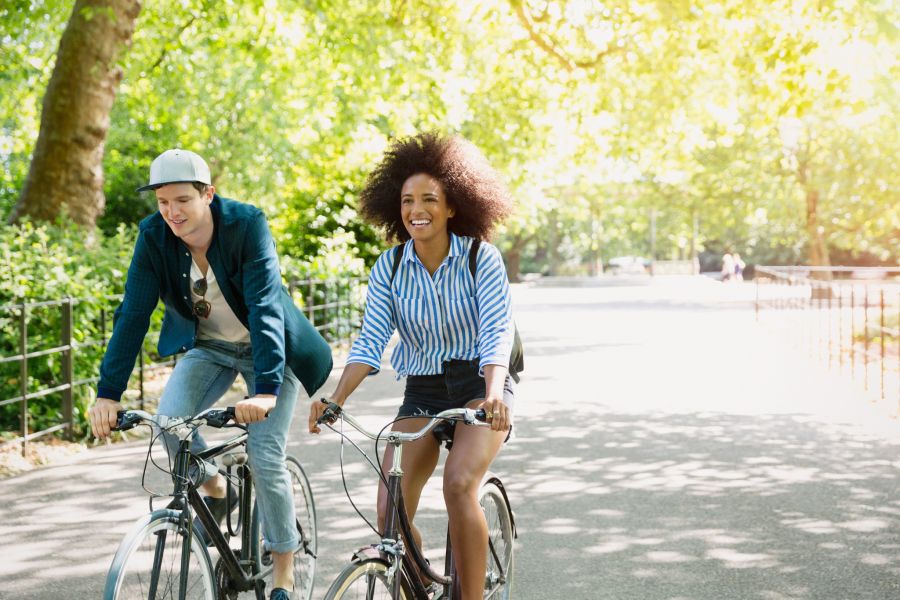 Young people on bikes riding through a park