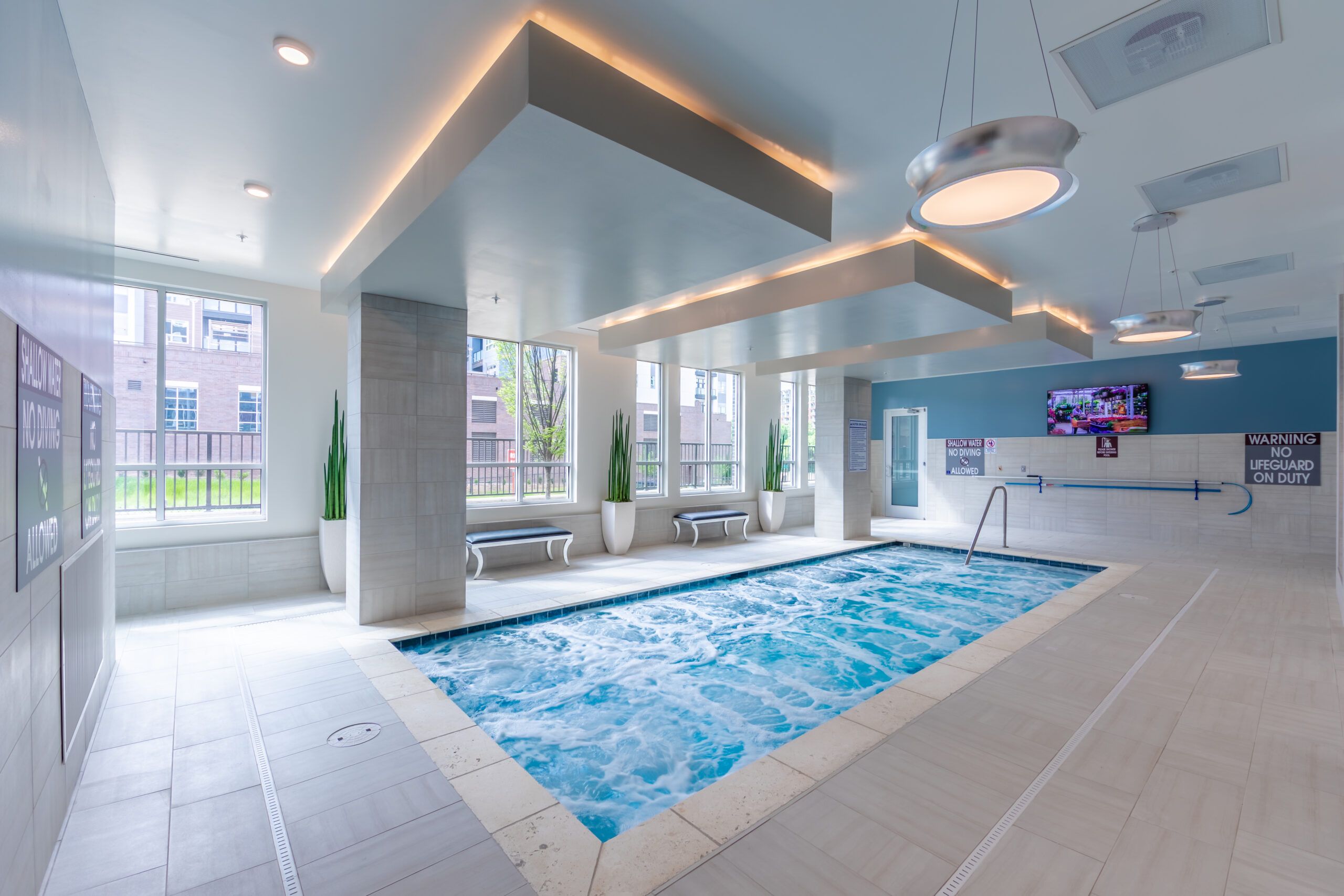 Residents in swimsuits walking in the pool area at Uptown 550 on Brooklyn apartments